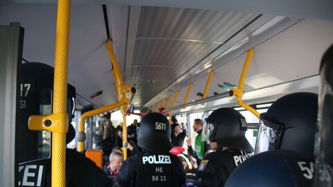 Bereitschaftspolizei begleitet Fans im Bus auf dem Weg zum Stadion.