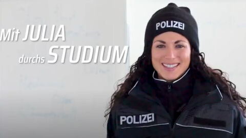 Eine Prau in Uniformjacke mit Polizeimütze.