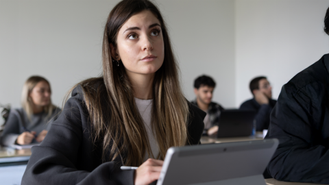 Kriminalkommissaranwärterin mit verschiedenen Unterrichtsmaterialien verfolgt eine Vorlesung