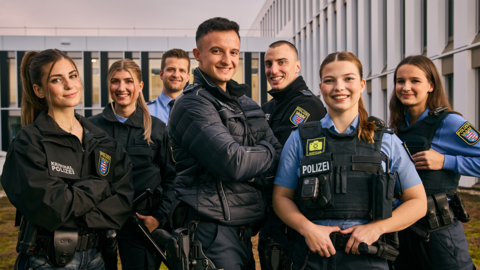 Sieben Polizeibeamtinnen und Polizeibeamte in Uniform posieren für ein Gruppenfoto
