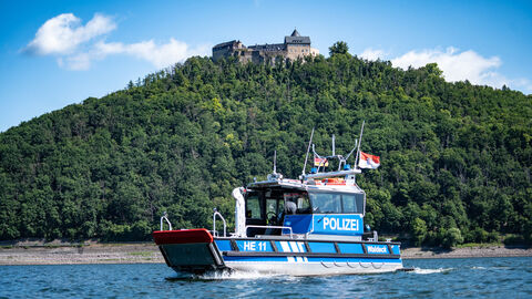 Polizeiboot Hessen 11 fährt auf dem Edersee, Burg Waldeck im Hintergrund