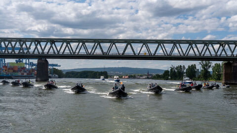 Mehrere Polizeiboote fahren in Formation auf die Kamera zu