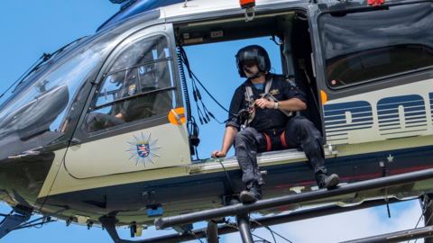 Ein Polizeibeamter der Fliegerstaffel bei Höhenrettung im Polizeihubschrauber.