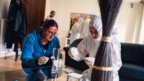 Eine Praktikantin und eine Kriminalkommissarin beim Spuren sichern.