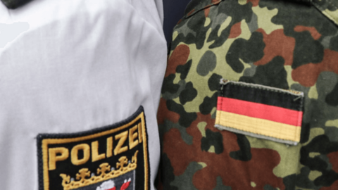 Die Schultern eines Polizeibeamten aus Hessen in Uniform und eines Soldaten in Uniform