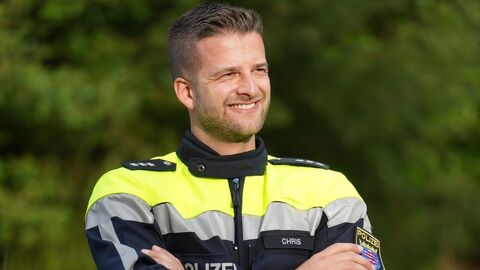 Polizeihauptkommissar Chris steht in Uniform auf dem Trainingsplatz