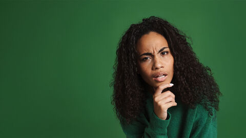 Eine Frau schaut fragend in die Kamera.